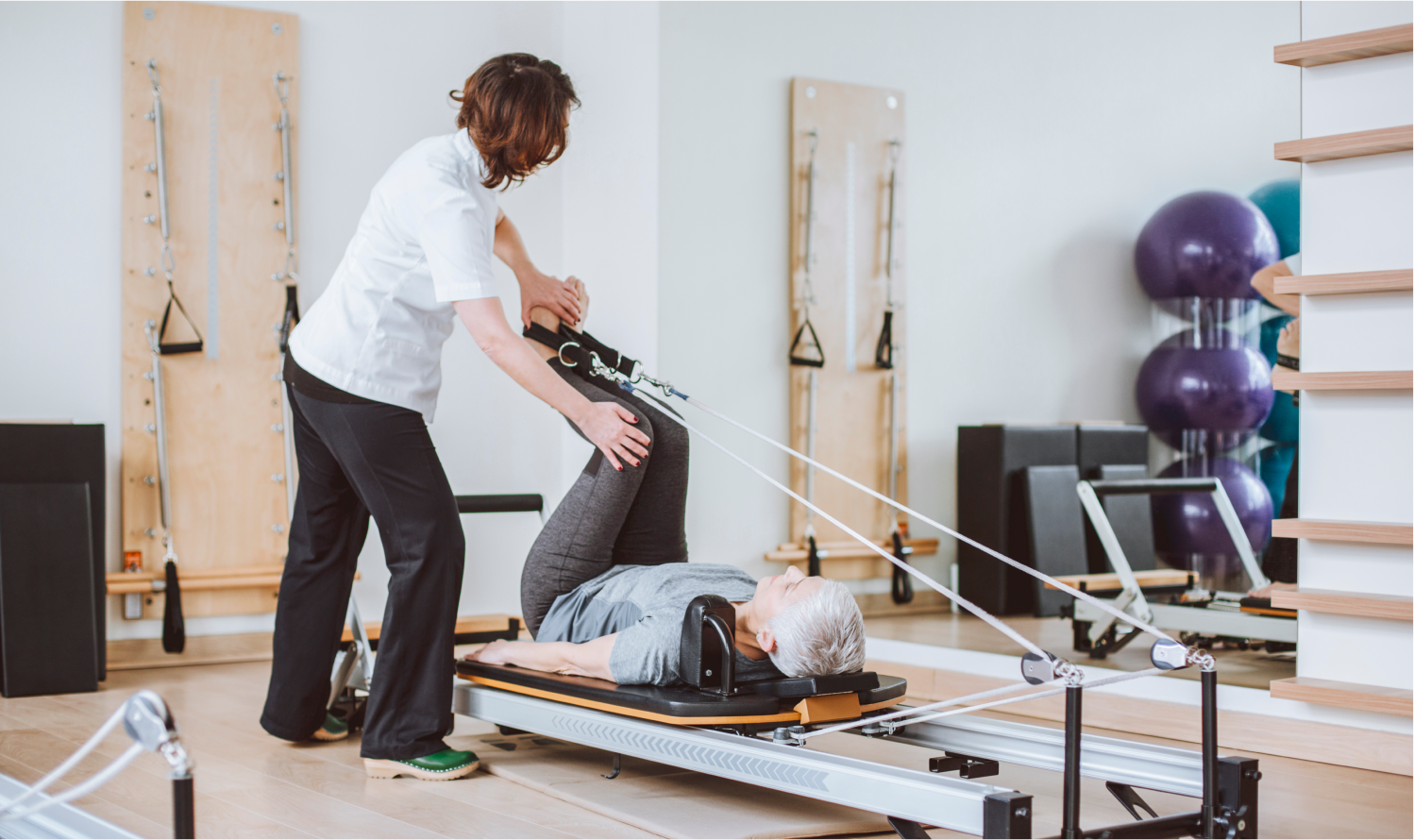 Physical therapist working with patient on pully machine.